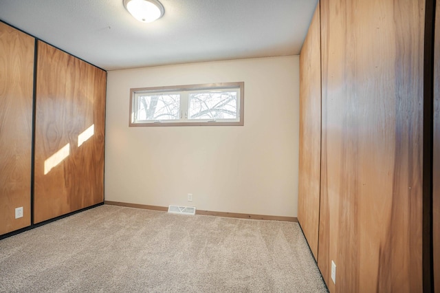 unfurnished bedroom with light colored carpet and a closet