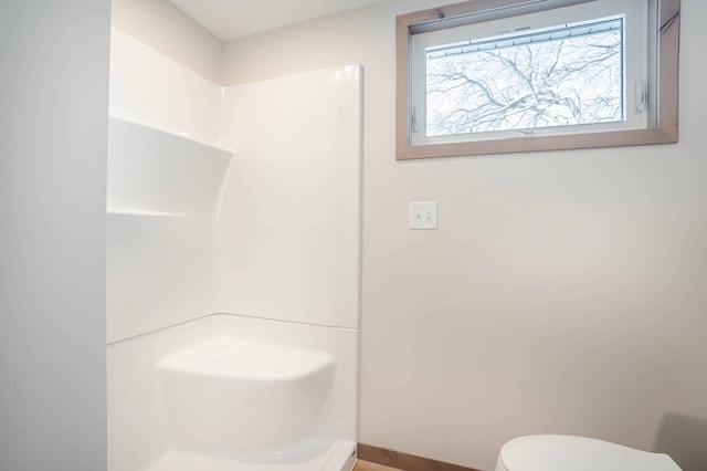 bathroom featuring walk in shower and toilet