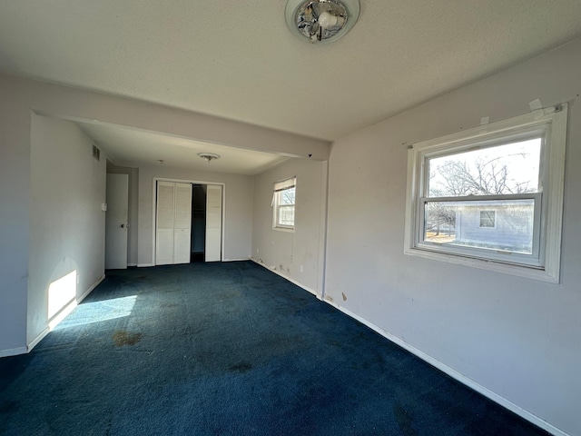 empty room with dark colored carpet