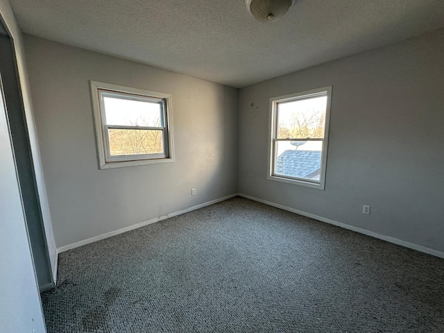 carpeted spare room featuring a textured ceiling