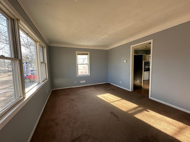 unfurnished room featuring dark carpet