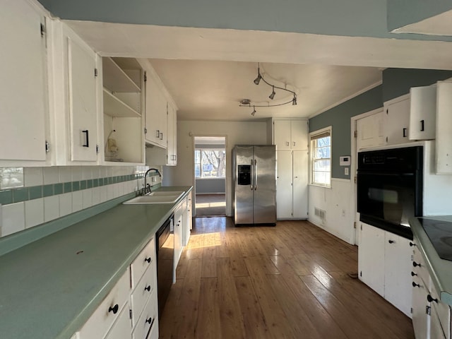 kitchen featuring dark wood-type flooring, black appliances, white cabinets, sink, and decorative backsplash