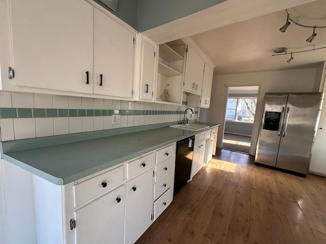 kitchen featuring white cabinetry, dishwasher, sink, stainless steel fridge, and decorative backsplash