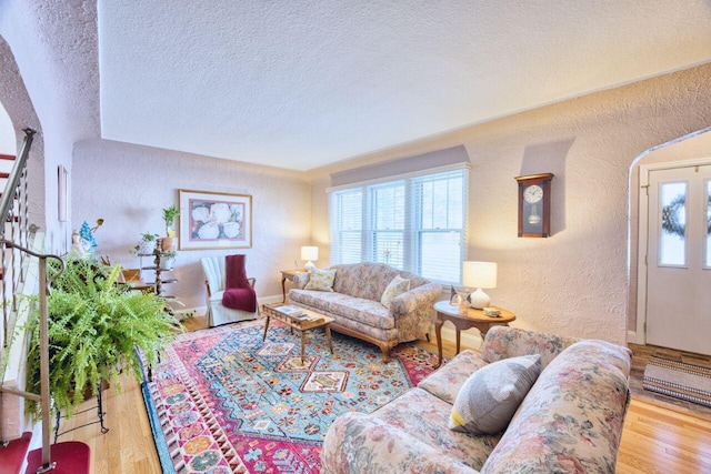 living room featuring a textured ceiling, hardwood / wood-style flooring, and plenty of natural light