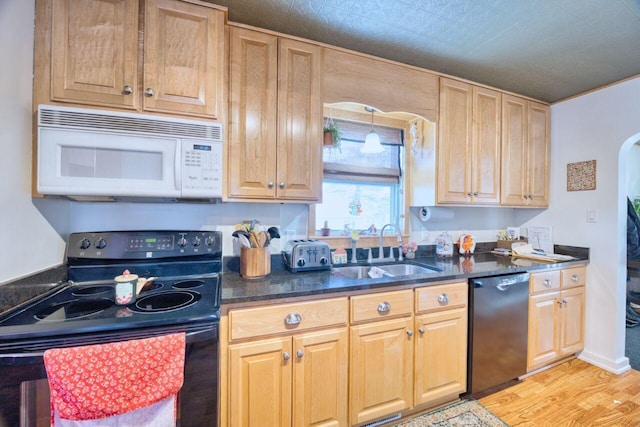 kitchen featuring black appliances, light hardwood / wood-style flooring, and sink