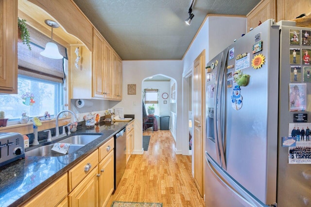 kitchen featuring appliances with stainless steel finishes, light hardwood / wood-style floors, pendant lighting, light brown cabinetry, and sink