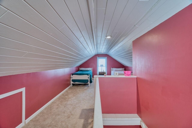 unfurnished bedroom featuring wood ceiling, vaulted ceiling, and light carpet