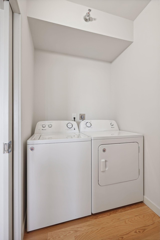 washroom featuring washing machine and dryer and light hardwood / wood-style floors