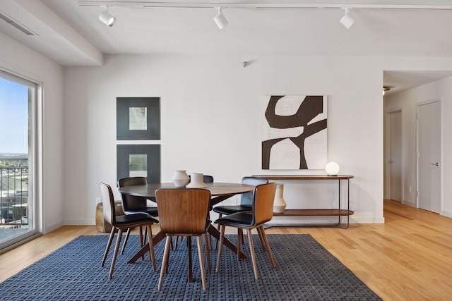 dining space featuring hardwood / wood-style flooring and rail lighting