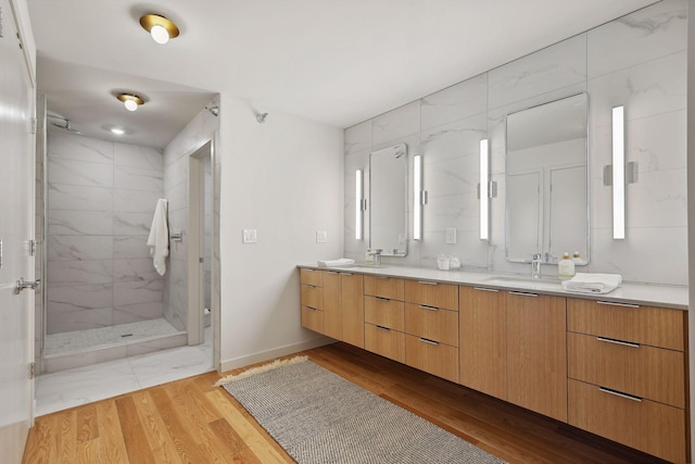 bathroom featuring hardwood / wood-style flooring, vanity, and walk in shower