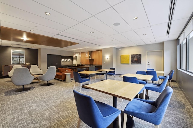 dining space with a paneled ceiling and light carpet