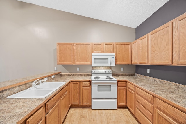 kitchen featuring white appliances, vaulted ceiling, light hardwood / wood-style floors, light brown cabinetry, and sink