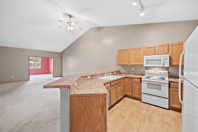 kitchen featuring white appliances, kitchen peninsula, lofted ceiling, ceiling fan, and sink