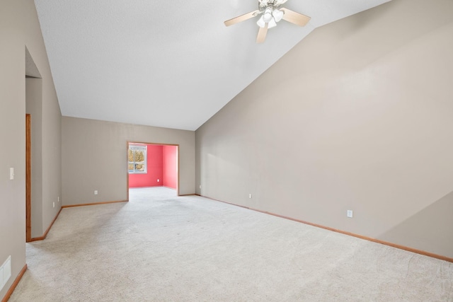 spare room featuring ceiling fan, light carpet, and lofted ceiling