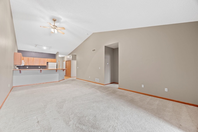 unfurnished living room featuring lofted ceiling, light carpet, and ceiling fan