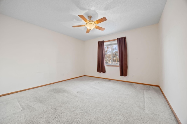 carpeted empty room featuring ceiling fan and a textured ceiling