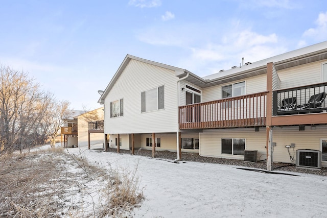 snow covered rear of property with central AC unit