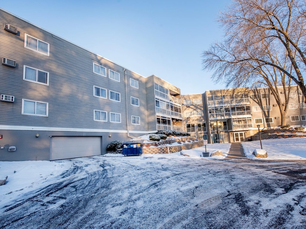 snow covered building featuring a garage