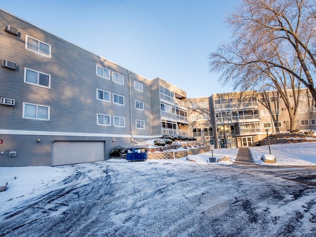 snow covered building featuring a garage