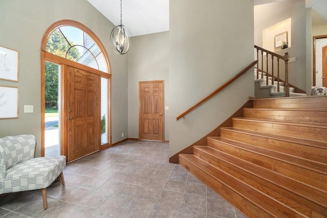 entryway featuring high vaulted ceiling and a chandelier