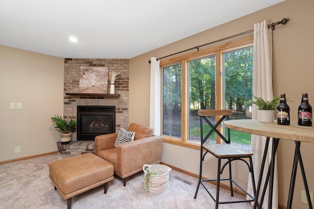 living area with carpet floors and a brick fireplace