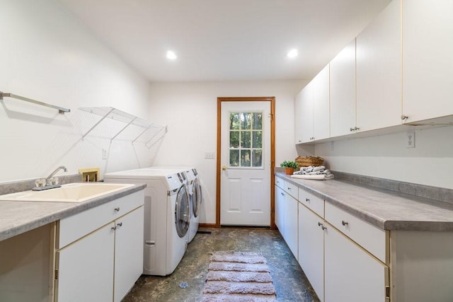 laundry area featuring washer and clothes dryer, cabinets, and sink