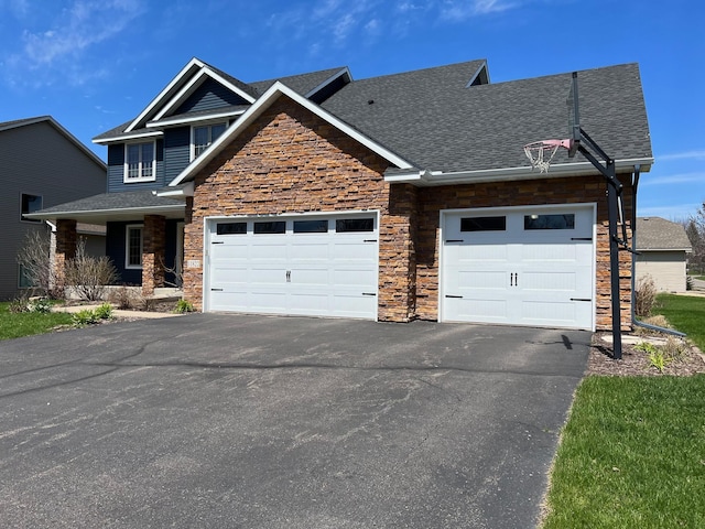 view of front facade featuring a garage, stone siding, roof with shingles, and aphalt driveway