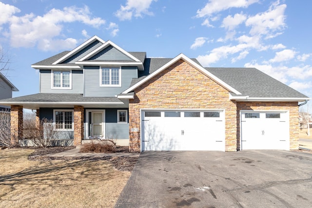 craftsman inspired home with a garage, driveway, a shingled roof, stone siding, and a porch