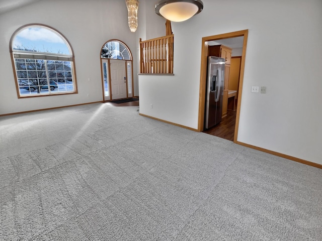 empty room with a high ceiling and dark carpet