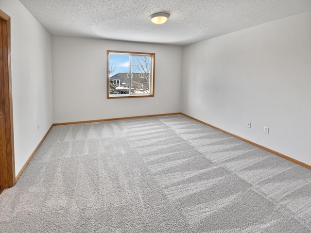 carpeted empty room with a textured ceiling