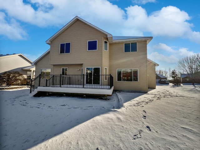 snow covered house with a deck