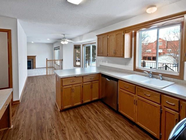 kitchen featuring kitchen peninsula, dishwasher, dark hardwood / wood-style floors, ceiling fan, and sink