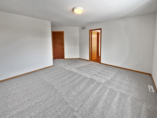 carpeted spare room featuring a textured ceiling