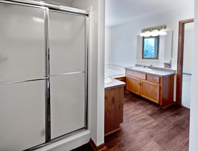 bathroom featuring a textured ceiling, separate shower and tub, vanity, and hardwood / wood-style flooring