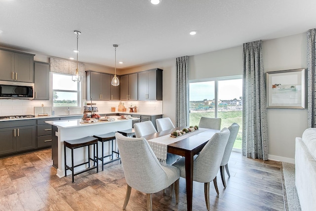 dining area featuring a textured ceiling and light hardwood / wood-style floors