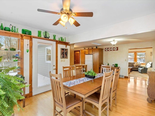 dining room with ceiling fan and light hardwood / wood-style floors