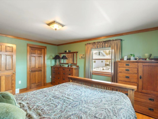 bedroom featuring ornamental molding and light wood-type flooring