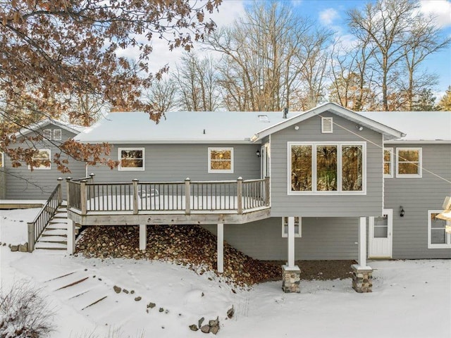 snow covered property with a deck