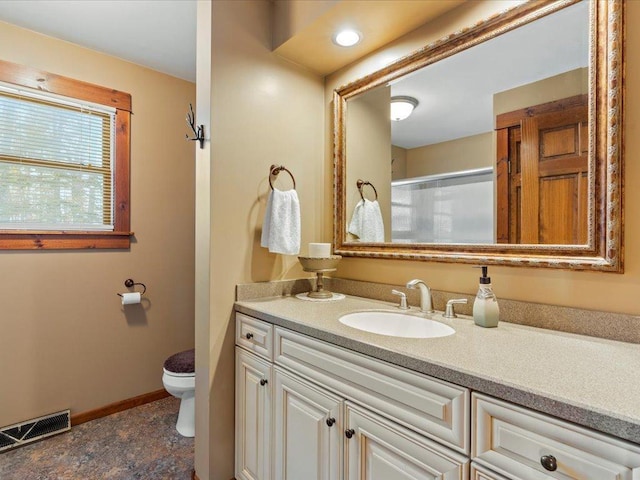 bathroom with vanity, a shower with shower door, and toilet