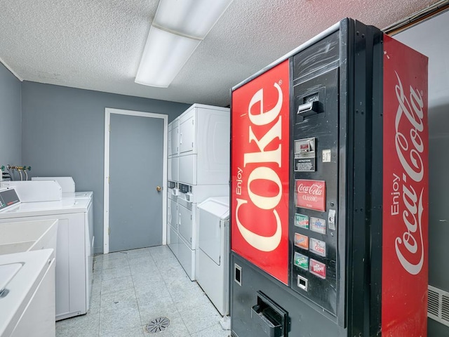 laundry area featuring stacked washer / drying machine, a textured ceiling, and independent washer and dryer