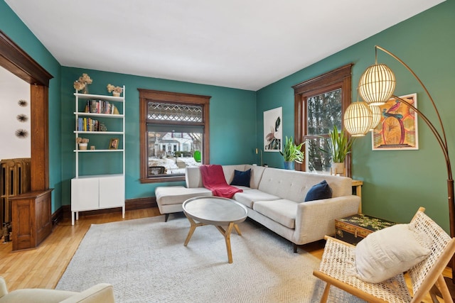 living room with hardwood / wood-style flooring, radiator heating unit, and a healthy amount of sunlight