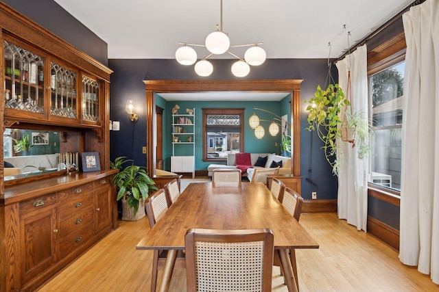 dining area with light hardwood / wood-style flooring and a chandelier