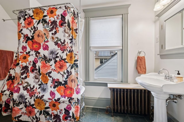 bathroom featuring walk in shower, tile patterned floors, and radiator