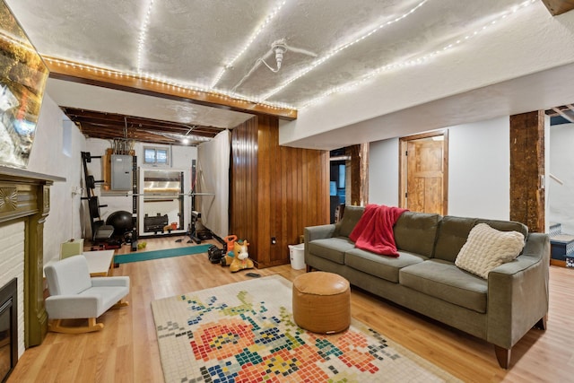 living room featuring hardwood / wood-style floors, electric panel, and wood walls