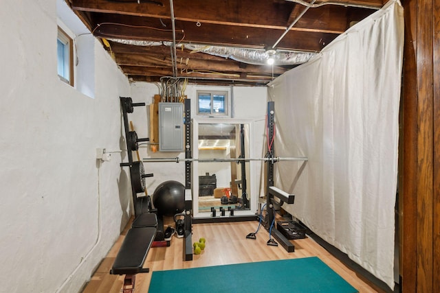 workout area with wood-type flooring and electric panel