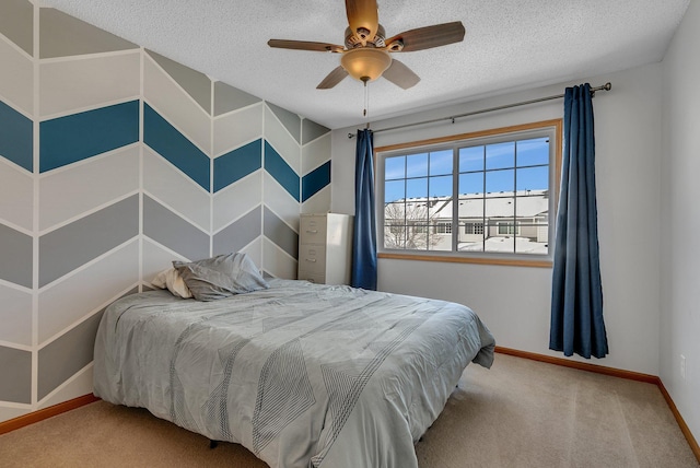 carpeted bedroom with a textured ceiling, ceiling fan, and baseboards