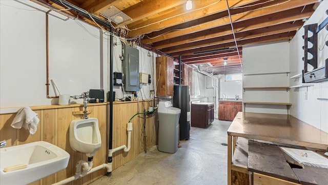 basement featuring electric panel, water heater, and sink