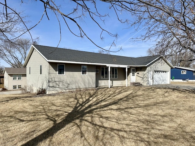 ranch-style home featuring a garage, roof with shingles, and aphalt driveway