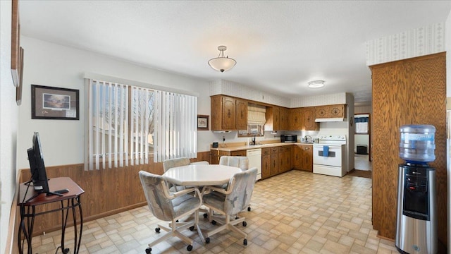 205 Ash St N, Sauk Centre, MN 56378 - dining room featuring wainscoting, wooden walls, and brick patterned flooring