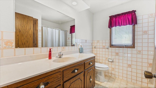 205 Ash St N, Sauk Centre, MN 56378 - bathroom featuring vanity, tile walls, toilet, a wainscoted wall, and a shower with shower curtain